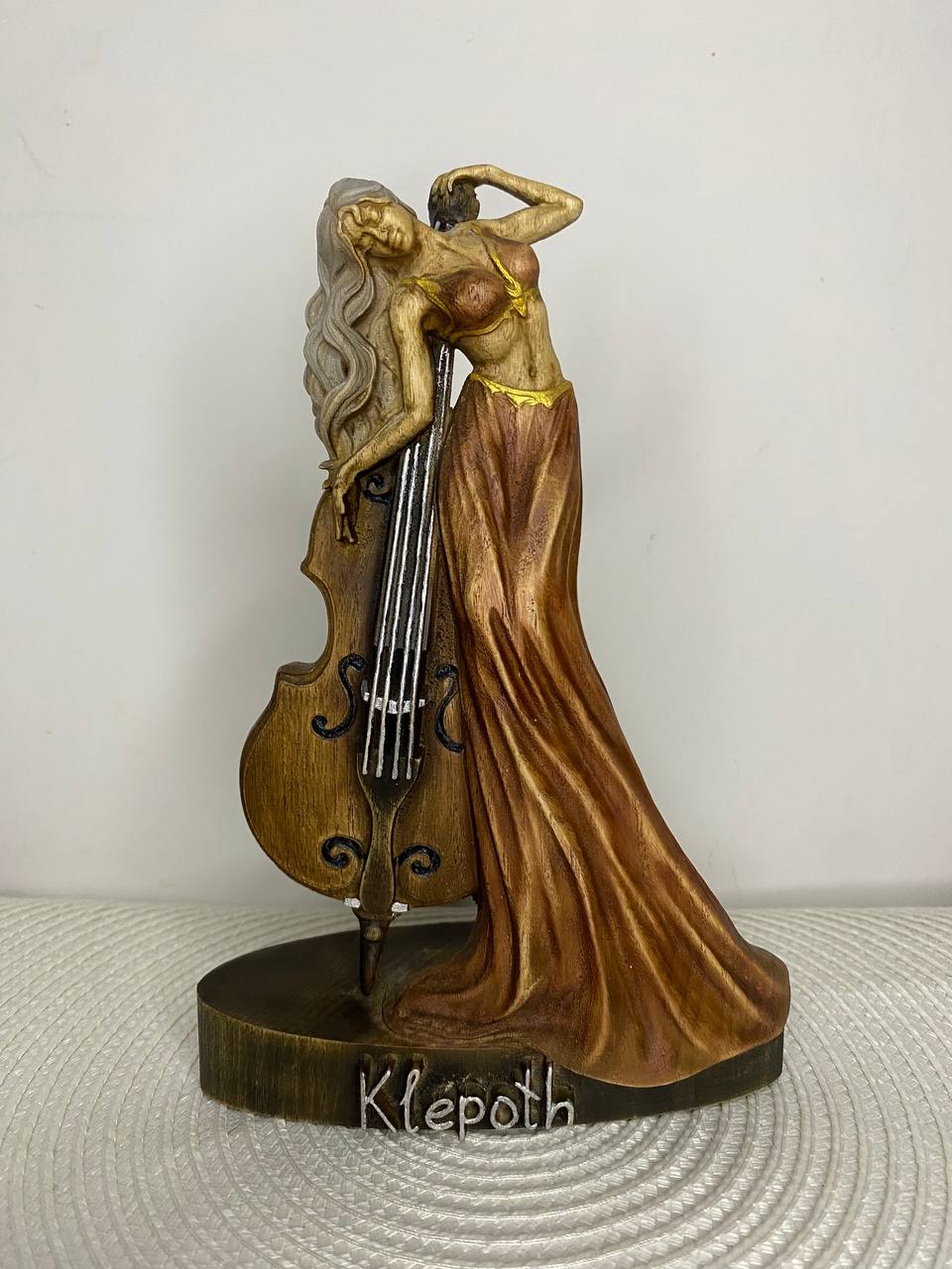 Hand-painted wooden statue of Klepoth, a dark fantasy demon violinist figure with flowing hair and long gown, leaning against a violin, inspired by gothic mystical art.
