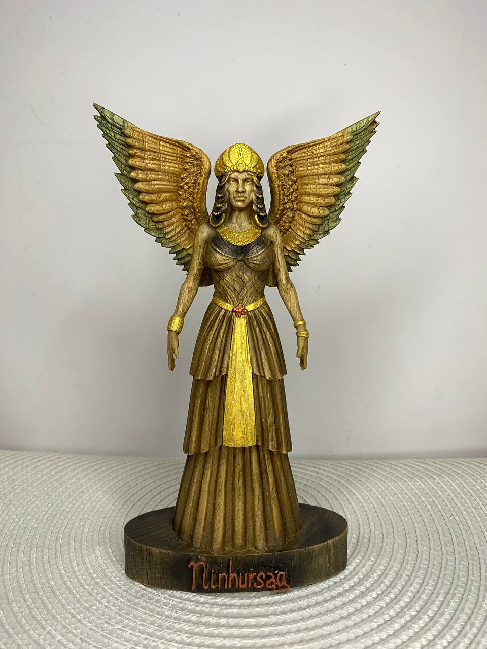 Hand-painted wooden statue of Ninhursag, Sumerian mother goddess with large wings and ceremonial dress, inspired by Mesopotamian mythology, sacred feminine symbolism, and spiritual altar decor.