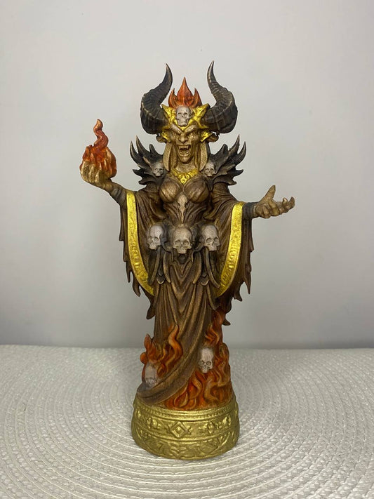 Statue with demonic features and gold accents on a textured surface