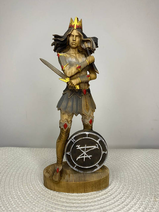Hand carved wooden statue of Terzian, fantasy warrior queen with crown, sword, and shield bearing a mystical sigil, inspired by dark mythology and gothic fantasy decor.
