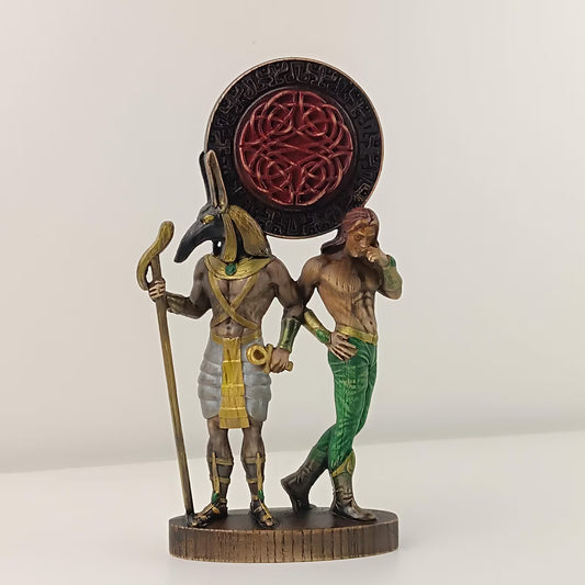 Statue of a figure with a headdress and another figure in green pants on a white background