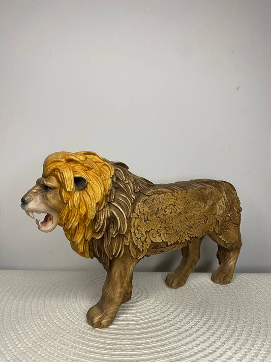 Hand-carved wooden lion statue with a detailed golden mane, open mouth and fangs, and intricate Celtic-inspired knotwork covering its body.